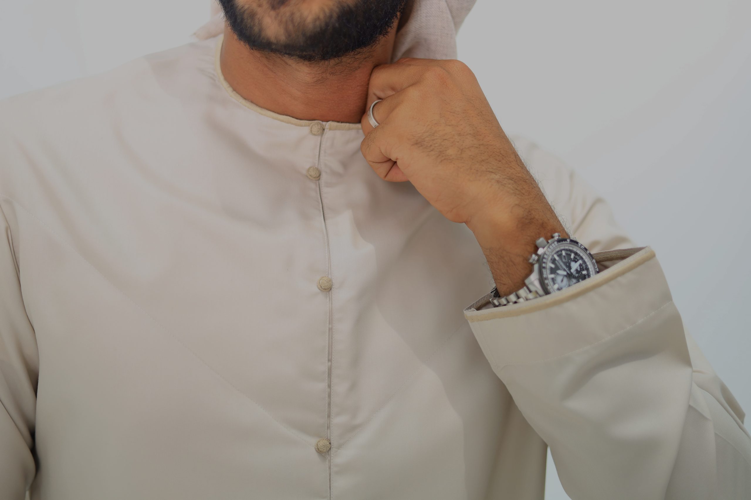 beige Emirati thobe with embroidery styled with a beige shemagh scarf