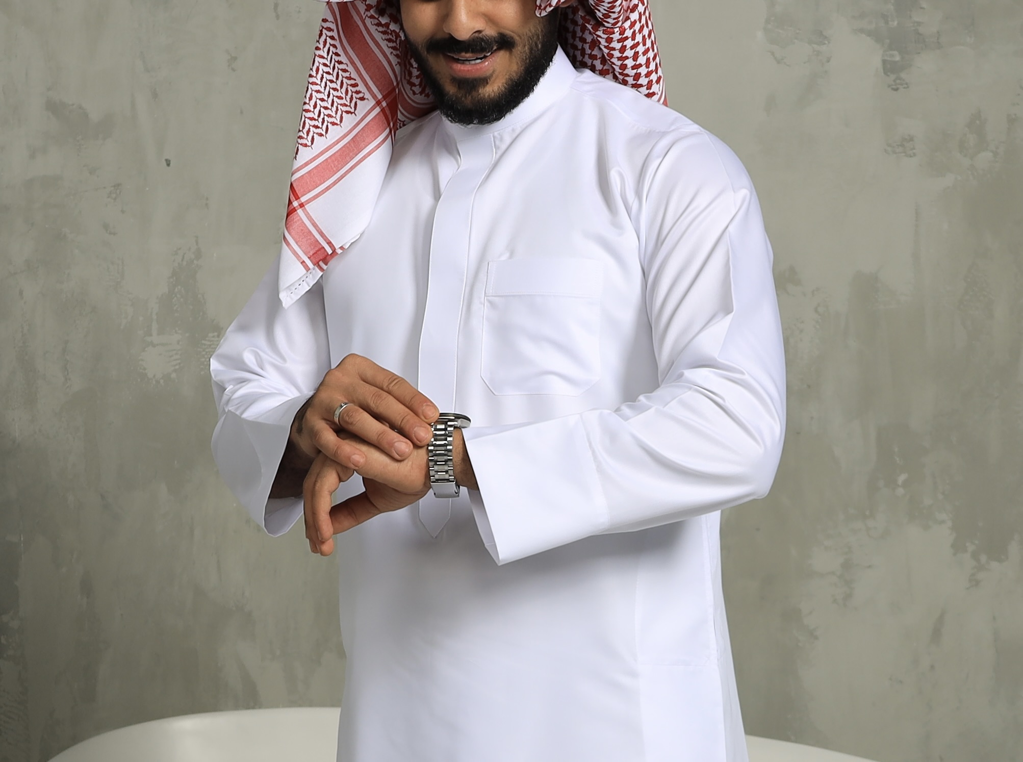 White Kuwaiti thobe styled with a red and white keffiyeh scarf