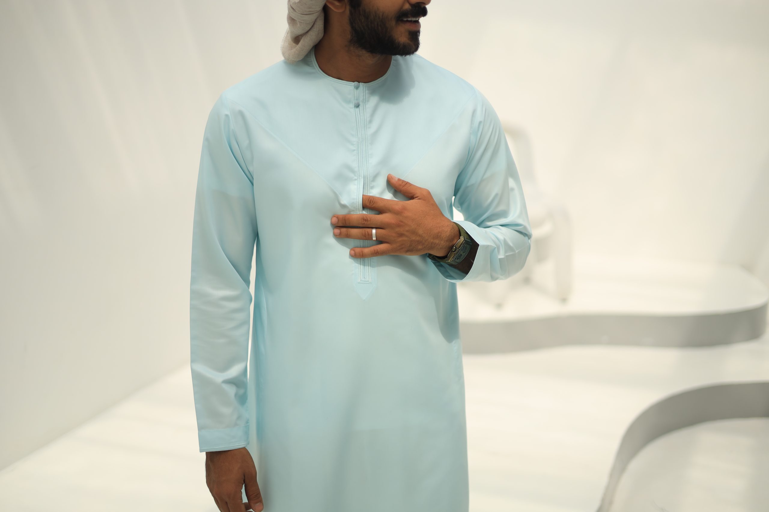 light blue Omani thobe styled with a beige Yemeni shemagh scarf