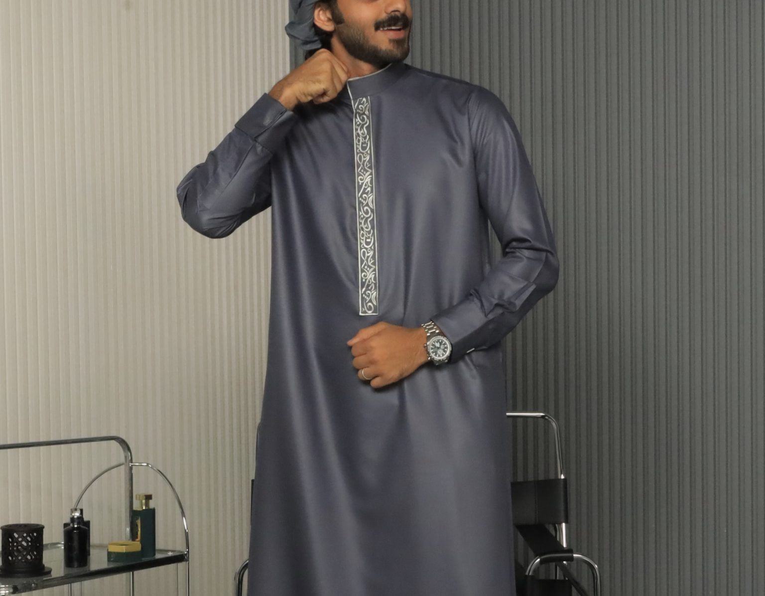 Close-up of silver embroidery on an Al Aniq grey collar thobe